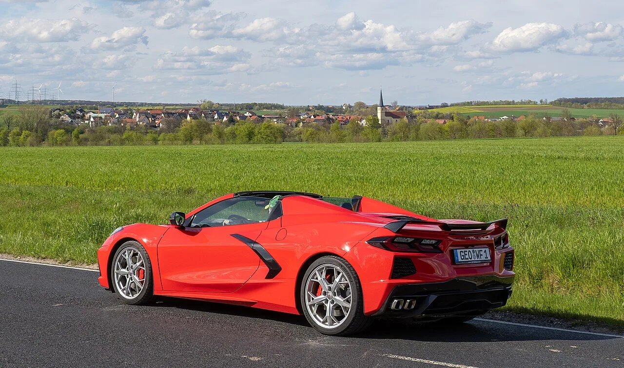 Een rode Chevrolet Corvette C8 cabriolet op een landweg